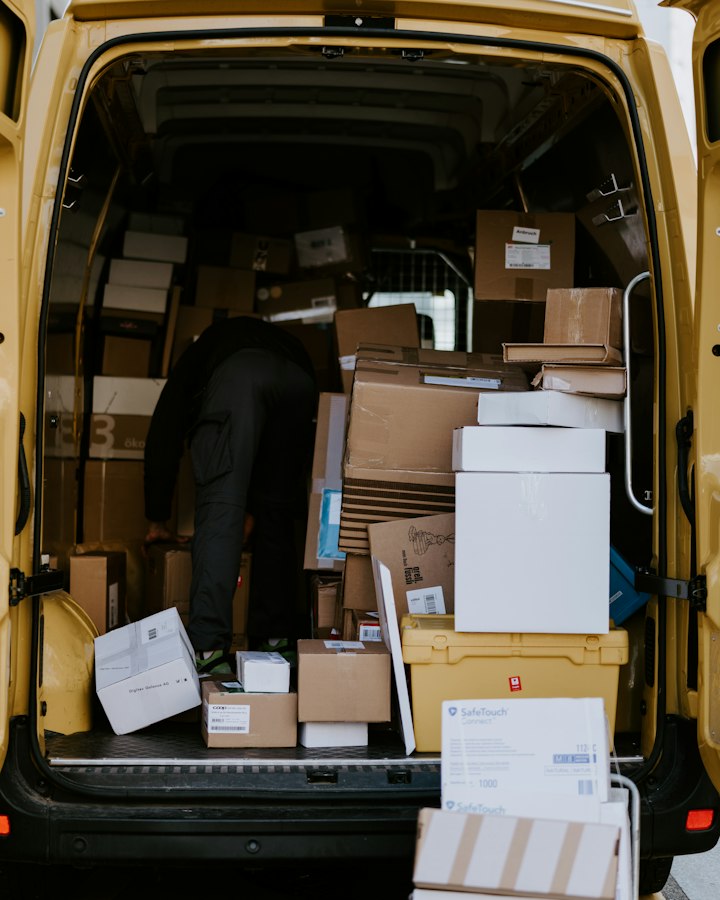 Delivery person loading boxes into a van
