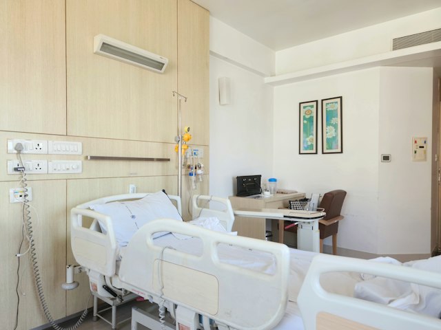 Empty hospital room with a bed and a desk
