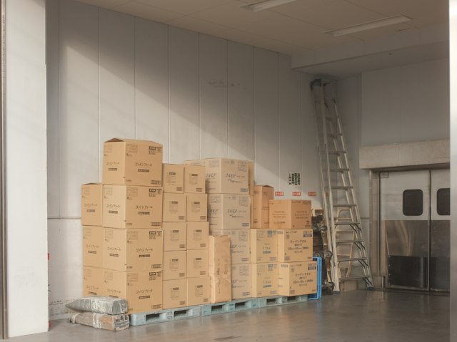 Cardboard supply boxes stacked on white floor tiles