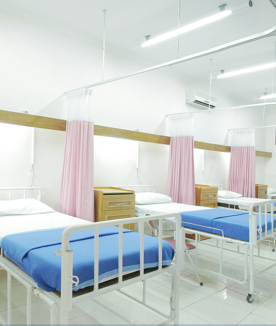 Bright hospital ward with a made bed and clinical equipment